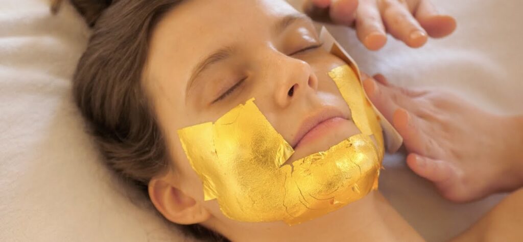 A woman receiving a 24-Karat Gold Stamp Facial at Modern Aestheticss, a premium skincare treatment for glowing and rejuvenated skin